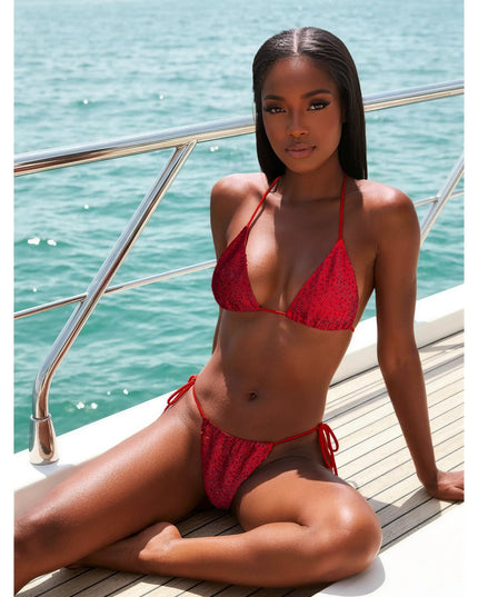 Woman wearing red crystal embellished  bikini set by Donna Di Luxury on boat deck with ocean view.